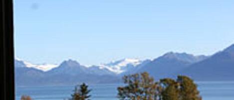 A balcony with a view of a mountain range and a body of water.