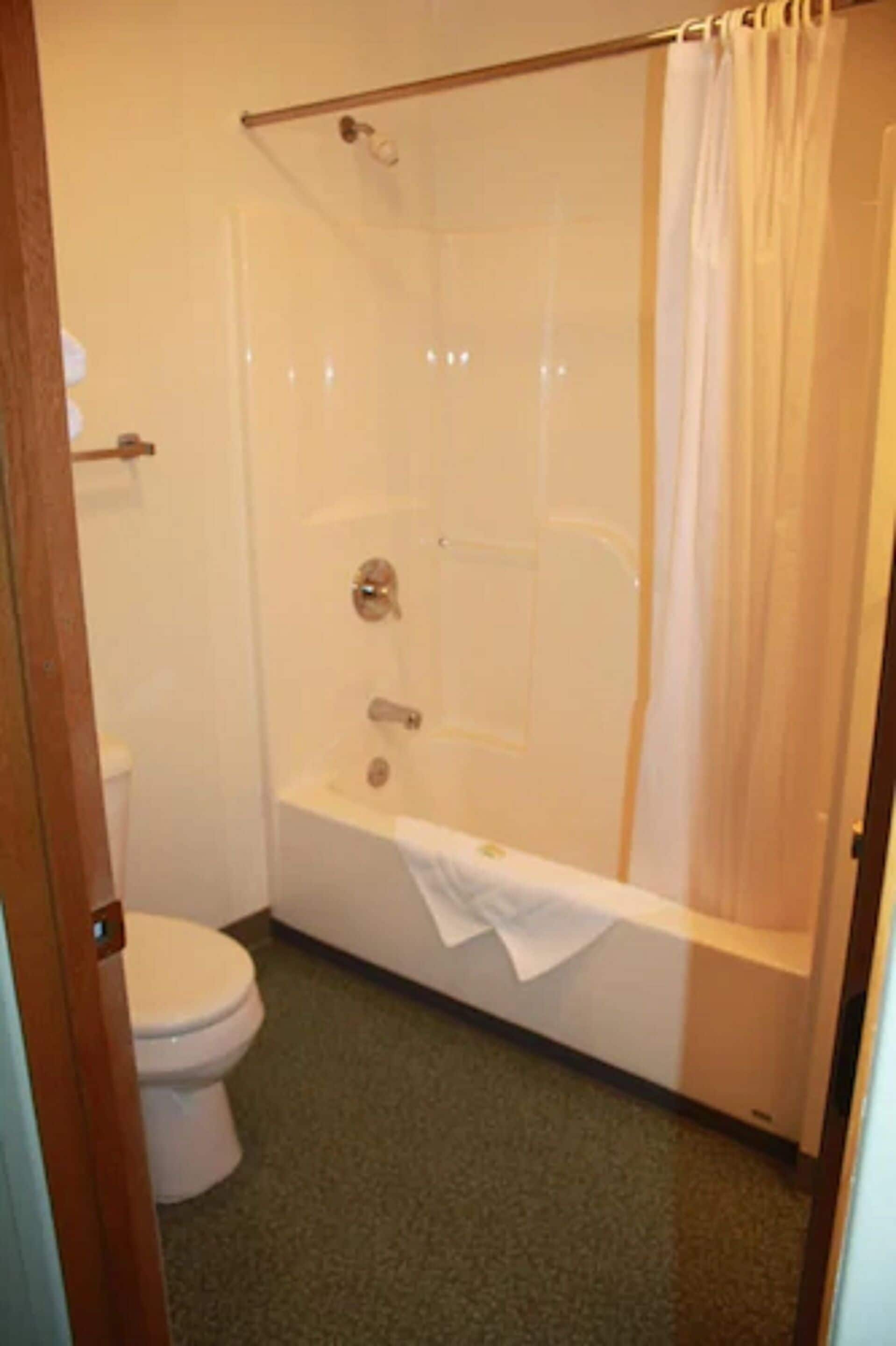 A bathroom with a glass-enclosed shower, a bathtub, and a toilet.
