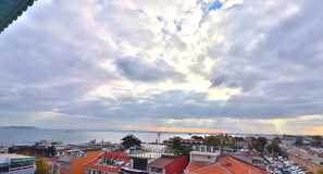 A coastal cityscape with buildings, a view of the sea, and a distant bridge. - Blue House Hotel (Istanbul)
