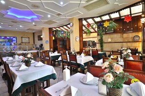A restaurant with tables set for dining, featuring a modern ceiling design and decorative flowers. - Blue House Hotel (Istanbul)
