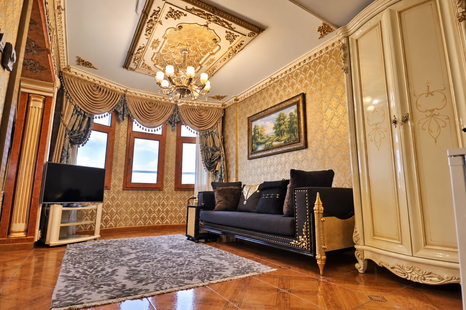A room with a sofa, television, and a cabinet.