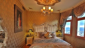 A luxurious bedroom with a large bed, ornate headboard, and a chandelier. - Blue House Hotel (Istanbul)