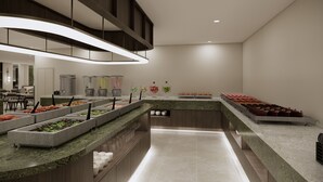 Un moderno montaje de bufé con varias estaciones de comida, una zona de estar y un mostrador con una variedad de platos.