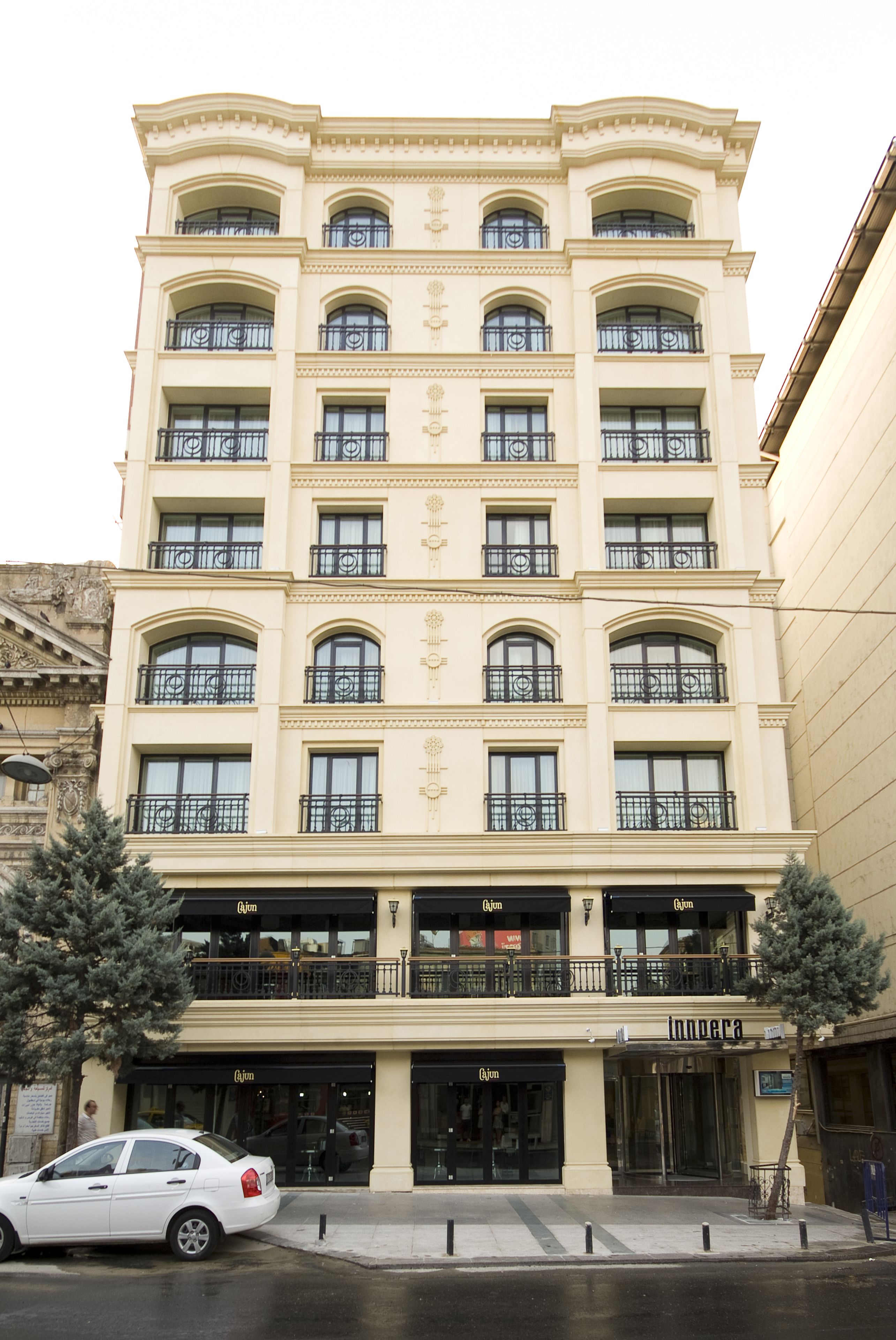 A multi-story hotel with a classic architectural style, featuring balconies and large windows.