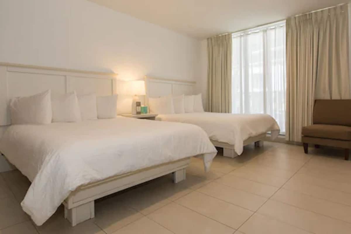 Suite, 1 Bedroom (2 Queens and 2 Doubles) | In-room safe, soundproofing, free WiFi, bed sheets