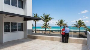 A modern building with a balcony overlooking a beach. - Premiere Hotel (Fort Lauderdale)