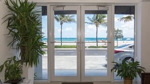A hotel entrance with a view of the beach and palm trees. - Premiere Hotel (Fort Lauderdale)