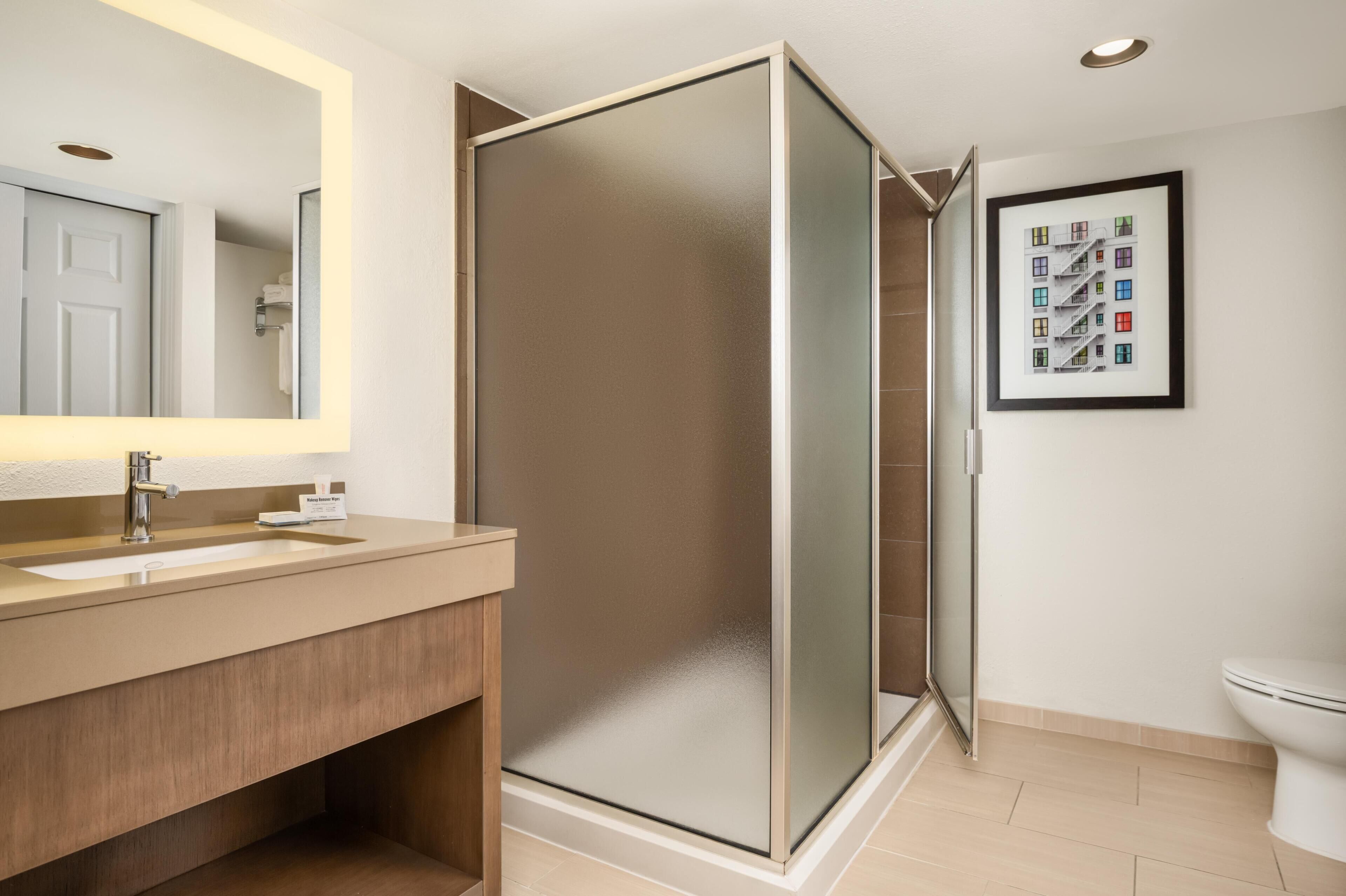 Een bad/douchecombinatie, designer toiletartikelen, een haardroger