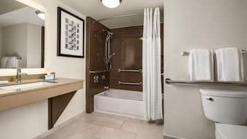 A modern bathroom with a sink, mirror, bathtub, shower, and toilet.