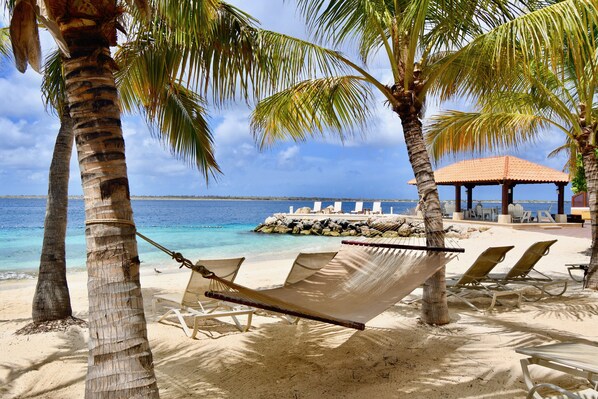 Aan een privéstrand, ligstoelen, parasols, strandlakens