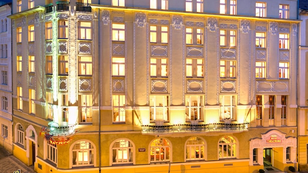 Ett hotell med flera våningar och en klassisk arkitektonisk design, med ett markant hörnstorn och en balkong på andra våningen.