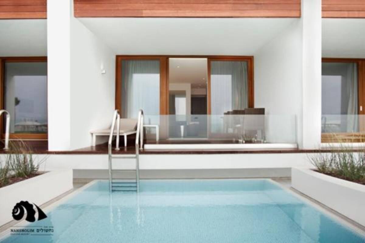 A modern building with a swimming pool, large windows, and a glass railing.