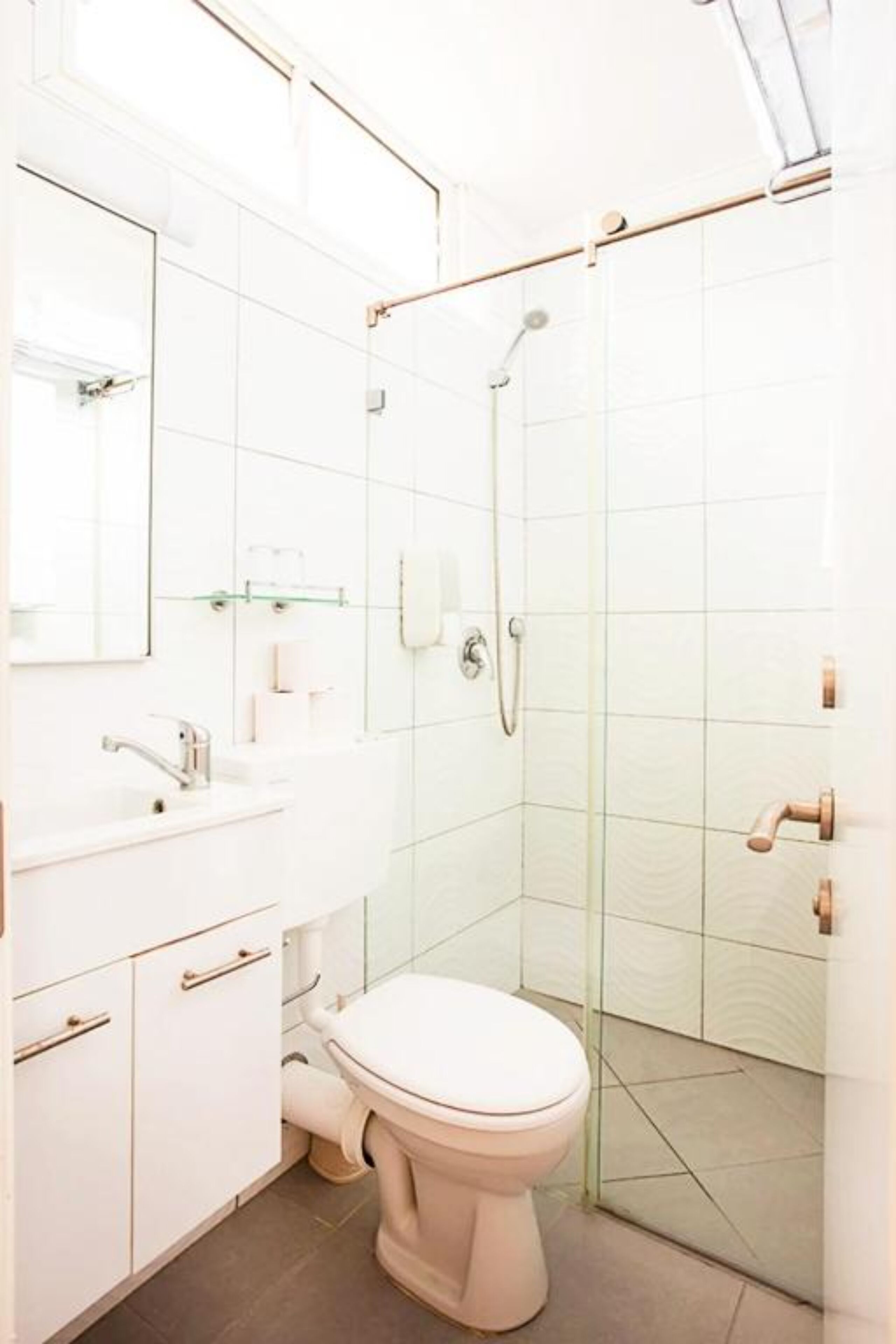 Ein modernes Badezimmer mit Toilette, Waschbecken und einer Duschkabine.