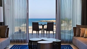 Una habitación con vista al mar, que incluye un sofá, dos sillones y una pequeña mesa.