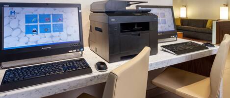 A hotel workspace with two Lenovo laptops, a Dell printer, and a marble countertop.