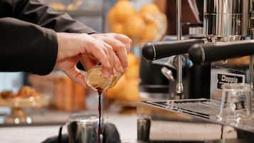 A barista preparing a drink at a coffee machine.