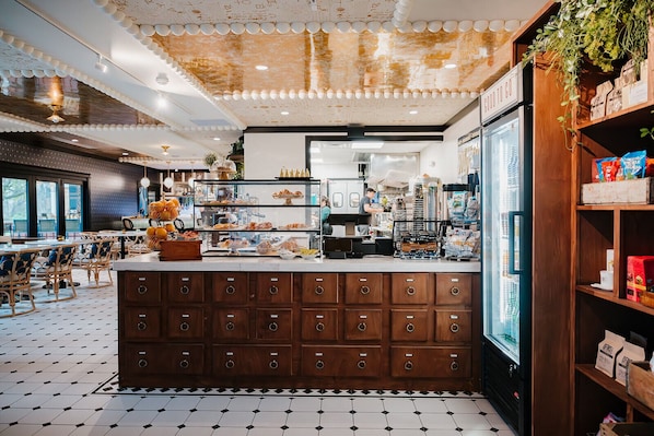 A cafe with a central counter, wooden cabinets, and a view of the city.