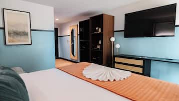 Ein Hotelzimmer mit einem Bett, einem großen Spiegel, einem Kleiderschrank, einem Fernseher und einem gerahmten Bild an der Wand.