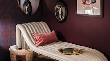 Relax in this stylish bedroom with a curved bed, framed artworks, and a round mirror.