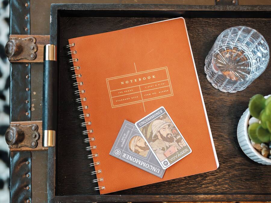 A notebook on a wooden tray with a metal clasp.