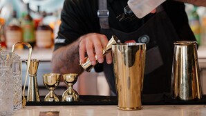 A bartender pouring a drink into a gold cocktail shaker. - Uncommoner Hotel by Reverie Boutique Collection (West Yarmouth)