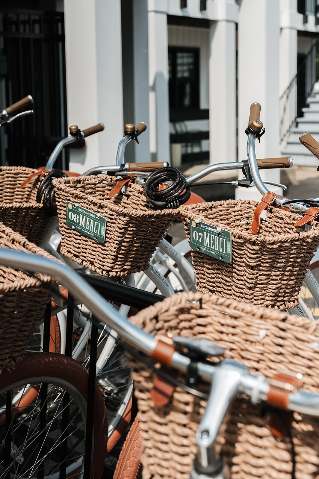 Una hilera de bicicletas con cestas de mimbre, cada una con la etiqueta 'Uncommon West Yarmouth'.