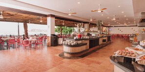 A spacious indoor dining area with red chairs and a central counter with food items. - HS HOTSSON Hotel Acapulco (Acapulco)