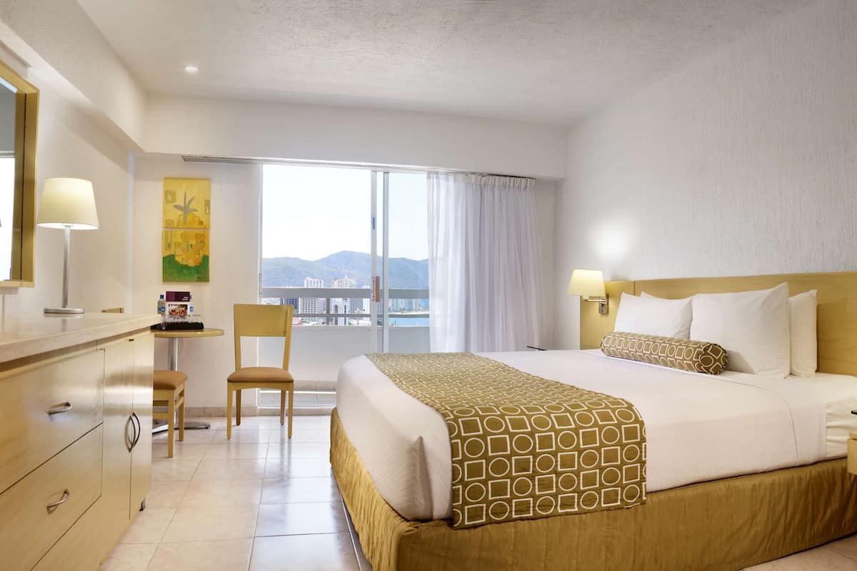 Chambre Deluxe, 1 très grand lit, balcon, vue partielle sur l'océan | Coffre-fort, bureau, espace de travail pour ordinateurs portables