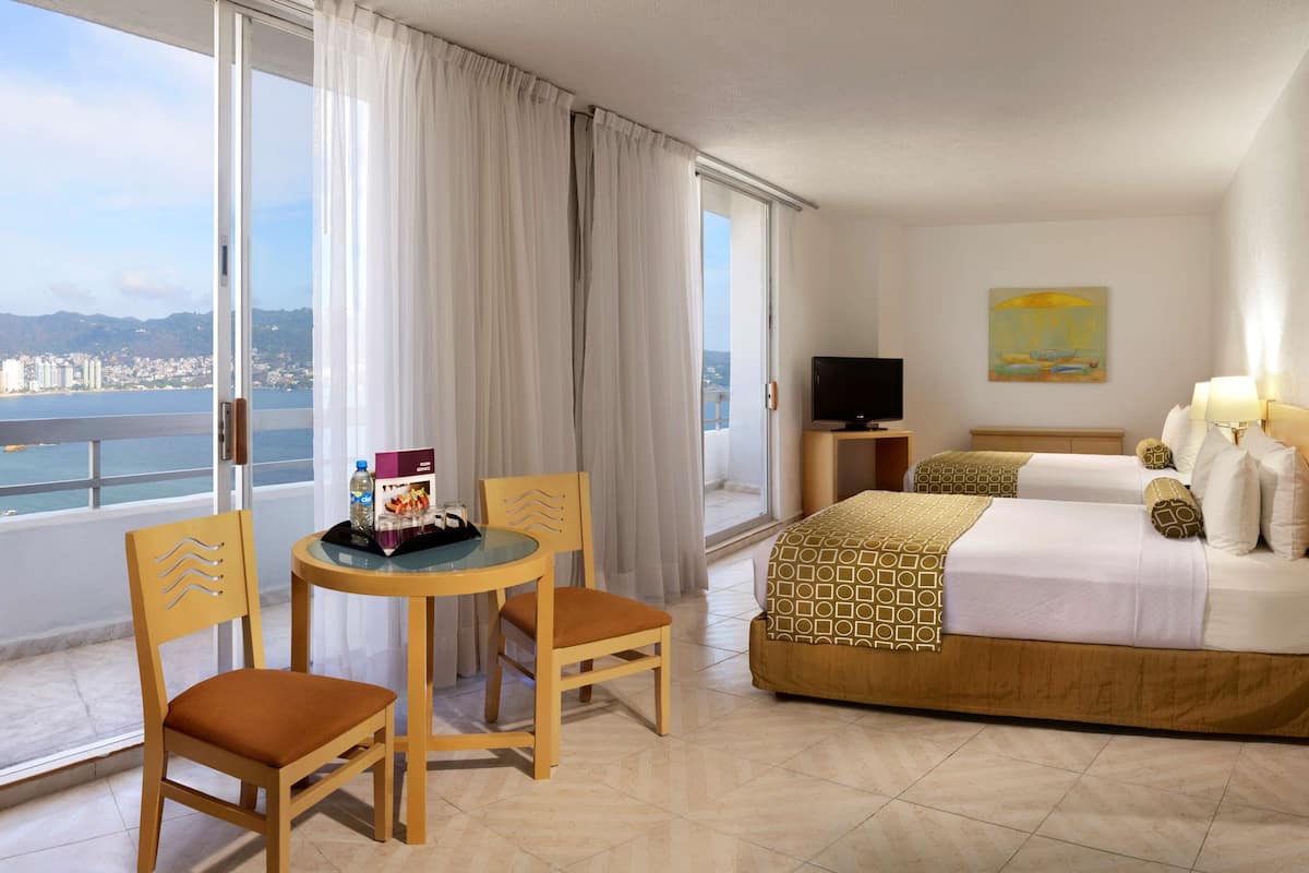 Suite Junior, 2 lits doubles, balcon, vue partielle sur l'océan | Coffre-fort, bureau, espace de travail pour ordinateurs portables