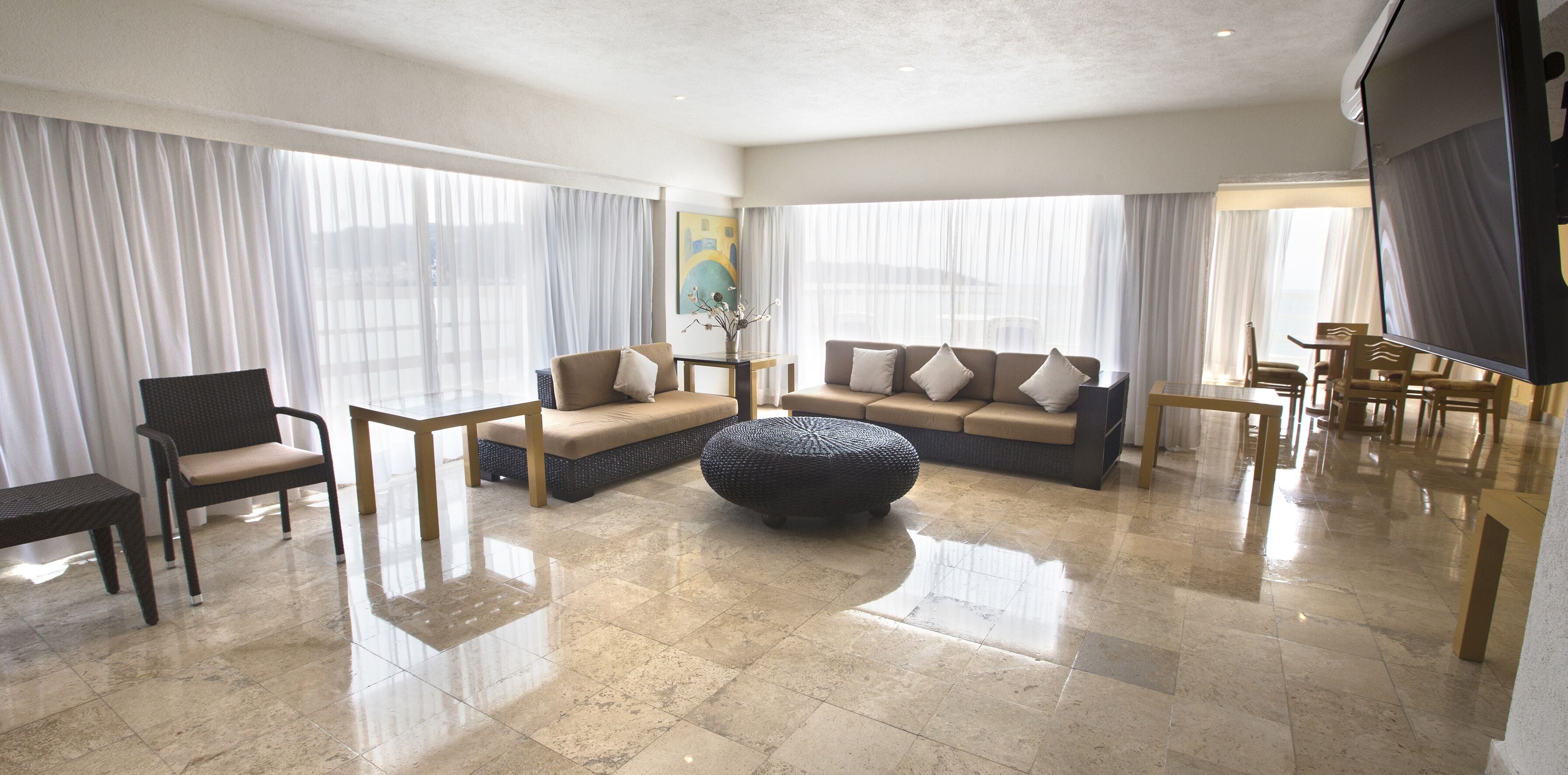 A spacious living room with a sofa set, a coffee table, and a TV.