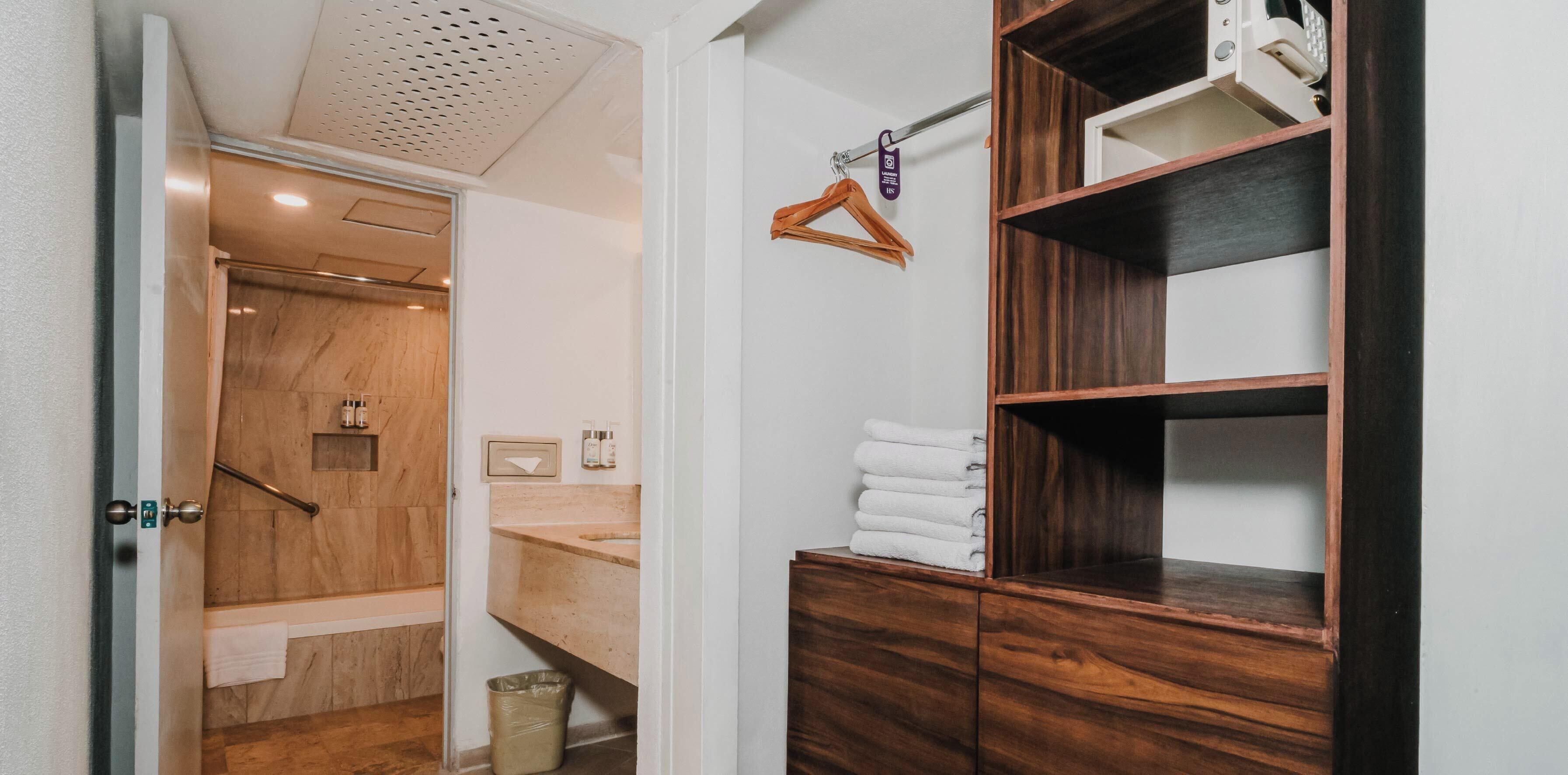 A bathroom with a wooden vanity, a towel rack, and a shower area.