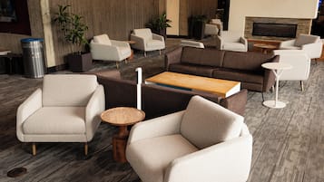 Een moderne zithoek met banken, fauteuils en een salontafel.