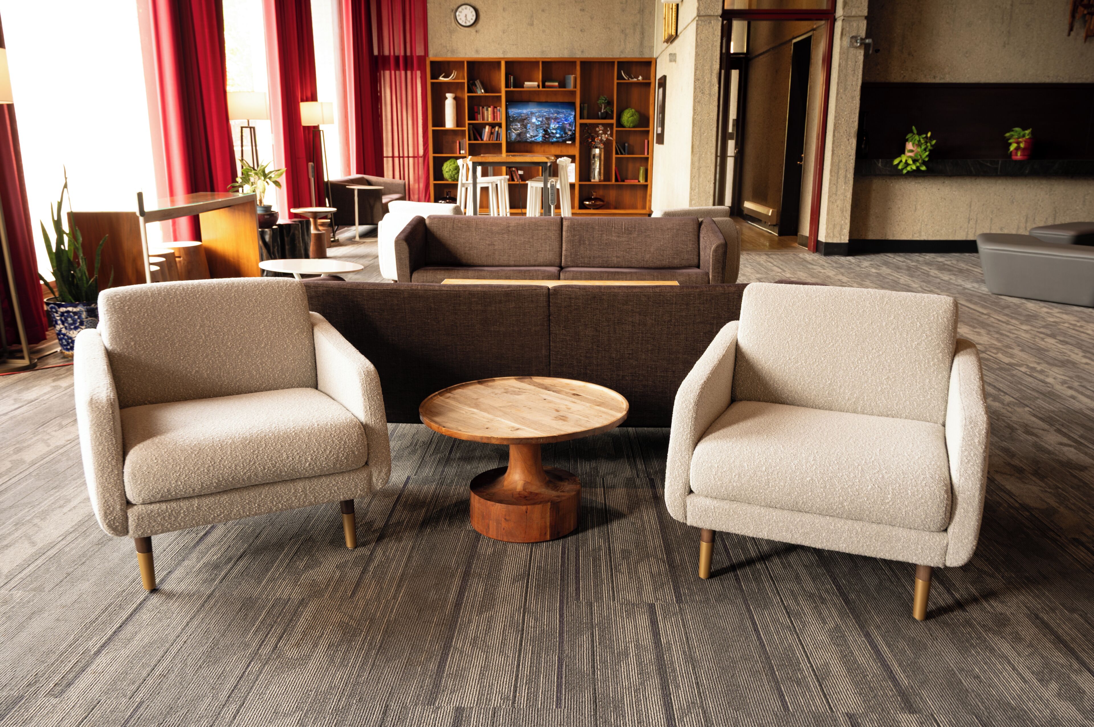 A modern living room with a sofa set, two armchairs, a wooden coffee table, and a television in the background.