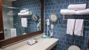 Un bagno con uno specchio grande, un lavandino, un water e un porta asciugamani con degli asciugamani.