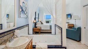 A bathroom with a sink, mirror, and bathtub. - The Reef Beach Resort, East End, Grand Cayman (East End)