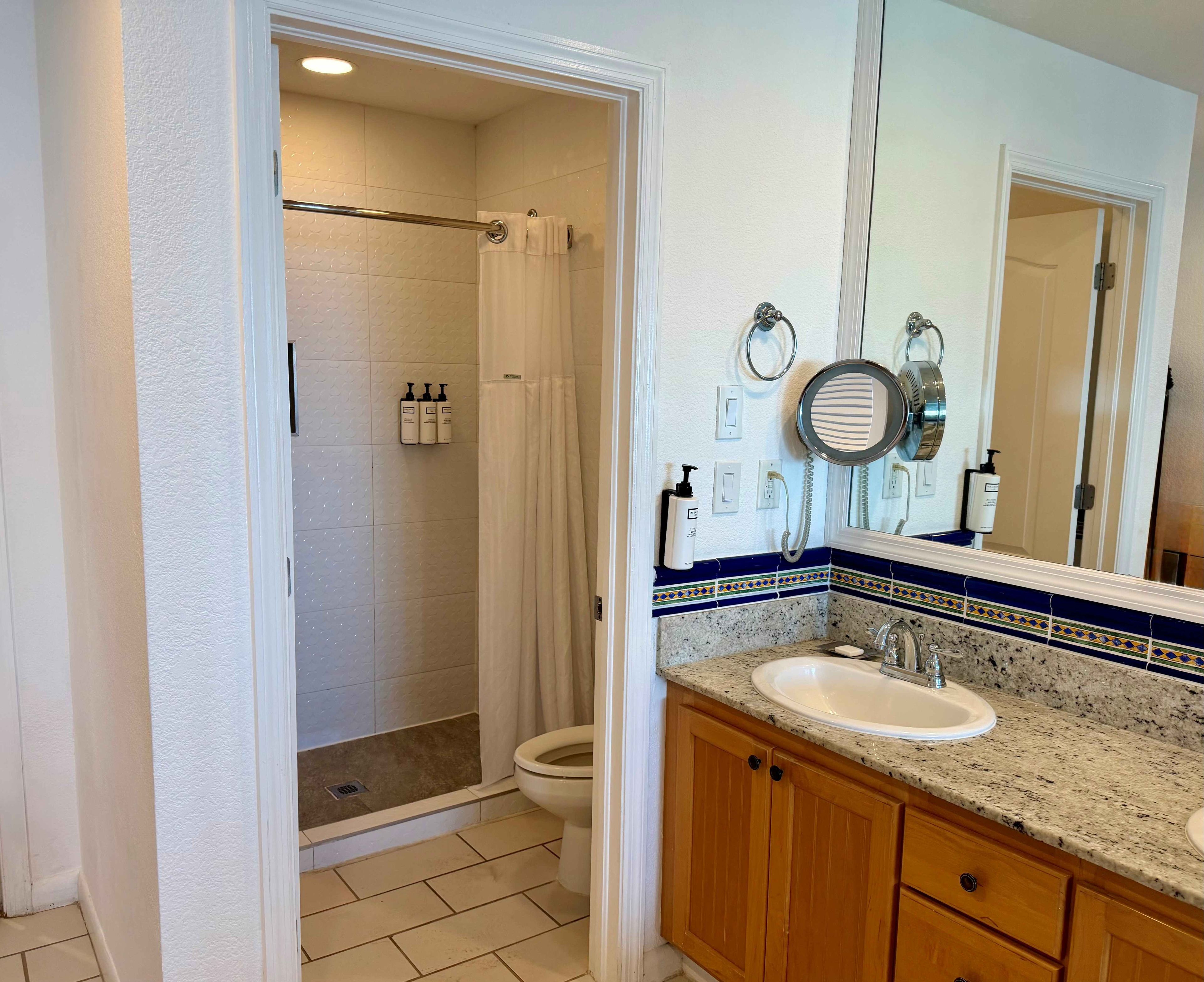 Une salle de bain équipée d’une douche, de toilettes, d’un lavabo et d’un meuble-lavabo.