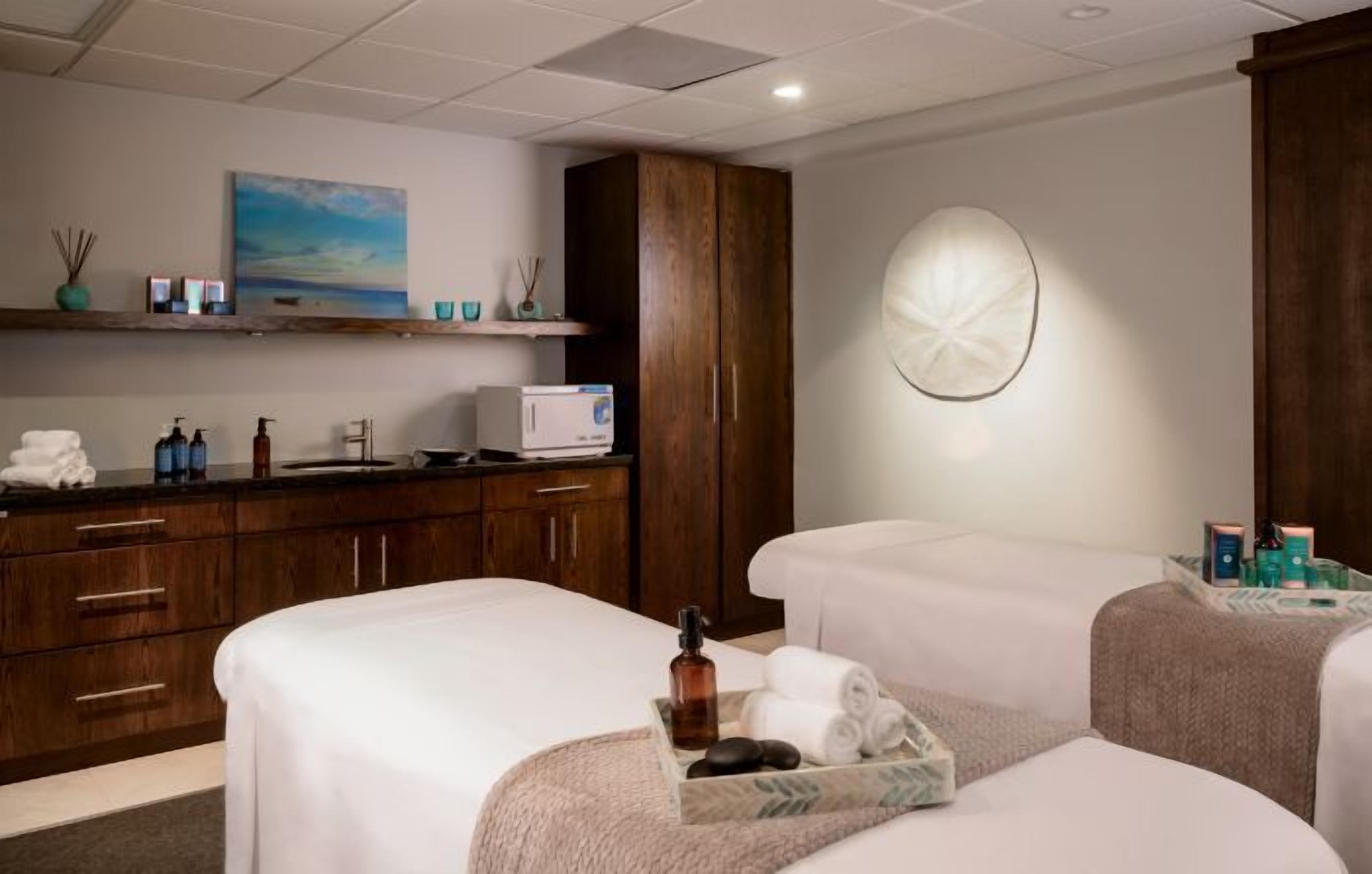 Une chambre d’hôtel avec deux lits, un minibar, un bureau et une grande fenêtre.