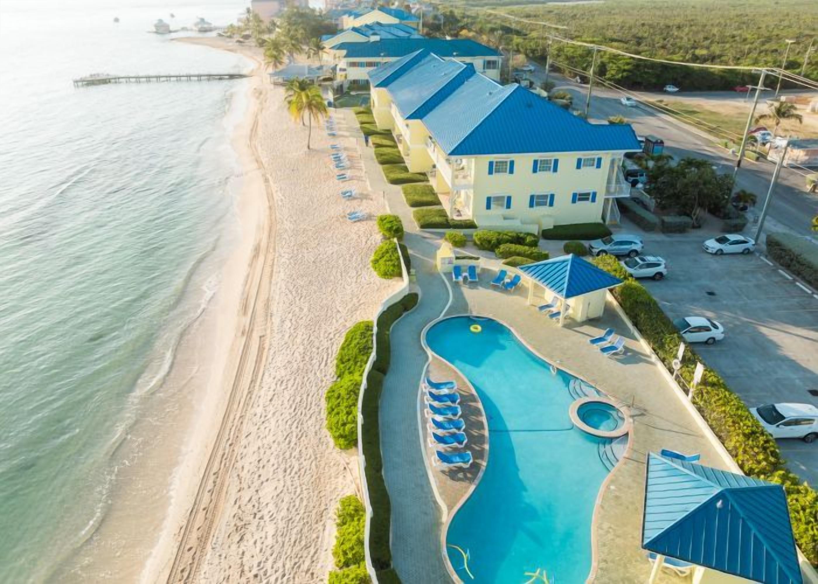 A resort with a swimming pool, beach, and multiple guest rooms.