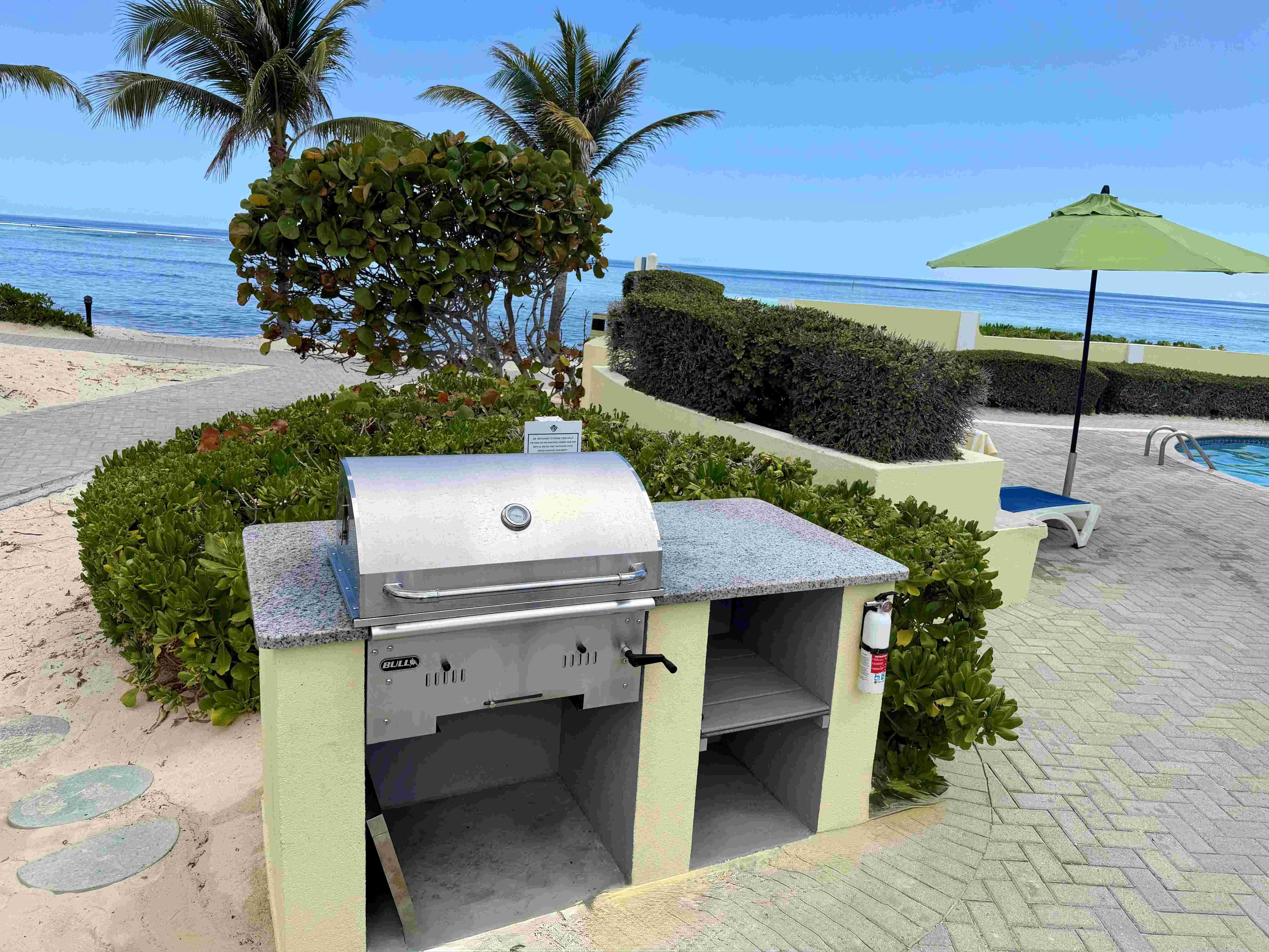Un barbecue avec vue sur l’océan et un espace piscine.