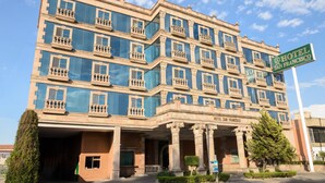Un hotel de varios pisos con fachada clásica, columnas y balcones.