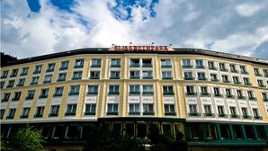 Een hotel met meerdere verdiepingen en een gebogen gevel, met een opvallend bord aan de bovenkant.