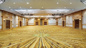 A large, well-lit room with a patterned floor, multiple doors, and chandeliers. - Marriott Anchorage Downtown (Anchorage)