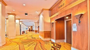 A hotel corridor with patterned carpet, wooden walls, and an exit sign. - Marriott Anchorage Downtown (Anchorage)
