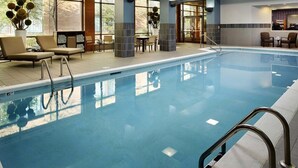 Una amplia piscina cubierta con sillones de descanso y una zona de estar.