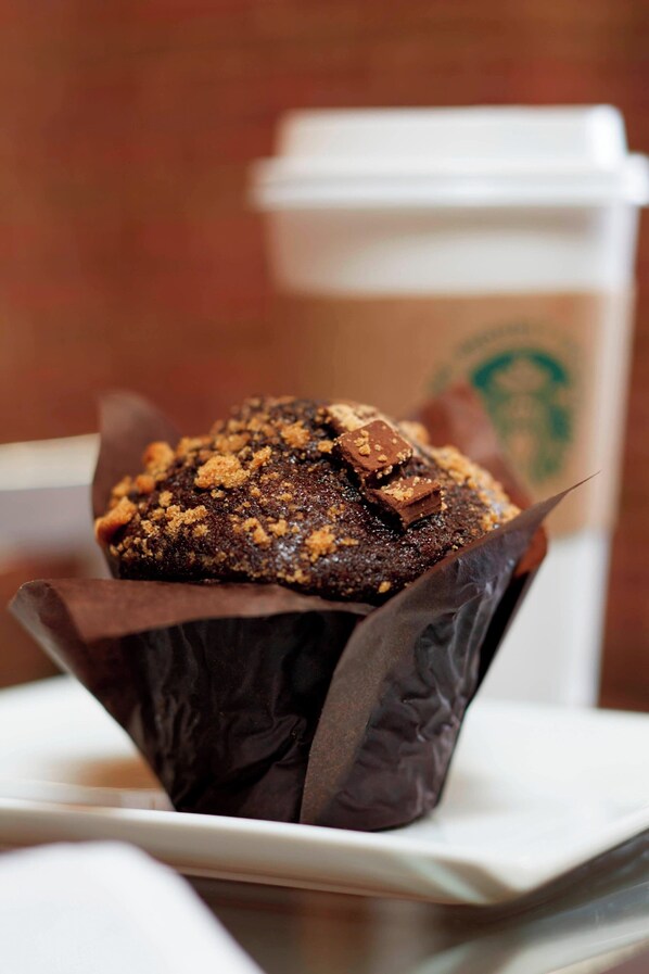 A muffin in a paper cup with a blurred background.