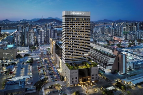 A JW Marriott hotel with a modern design, surrounded by a cityscape.. JW Marriott Hotel Seoul
