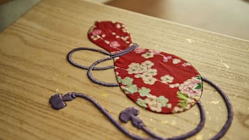 Une surface en bois sur laquelle repose un objet en tissu rouge orné de motifs floraux et de fils violets.