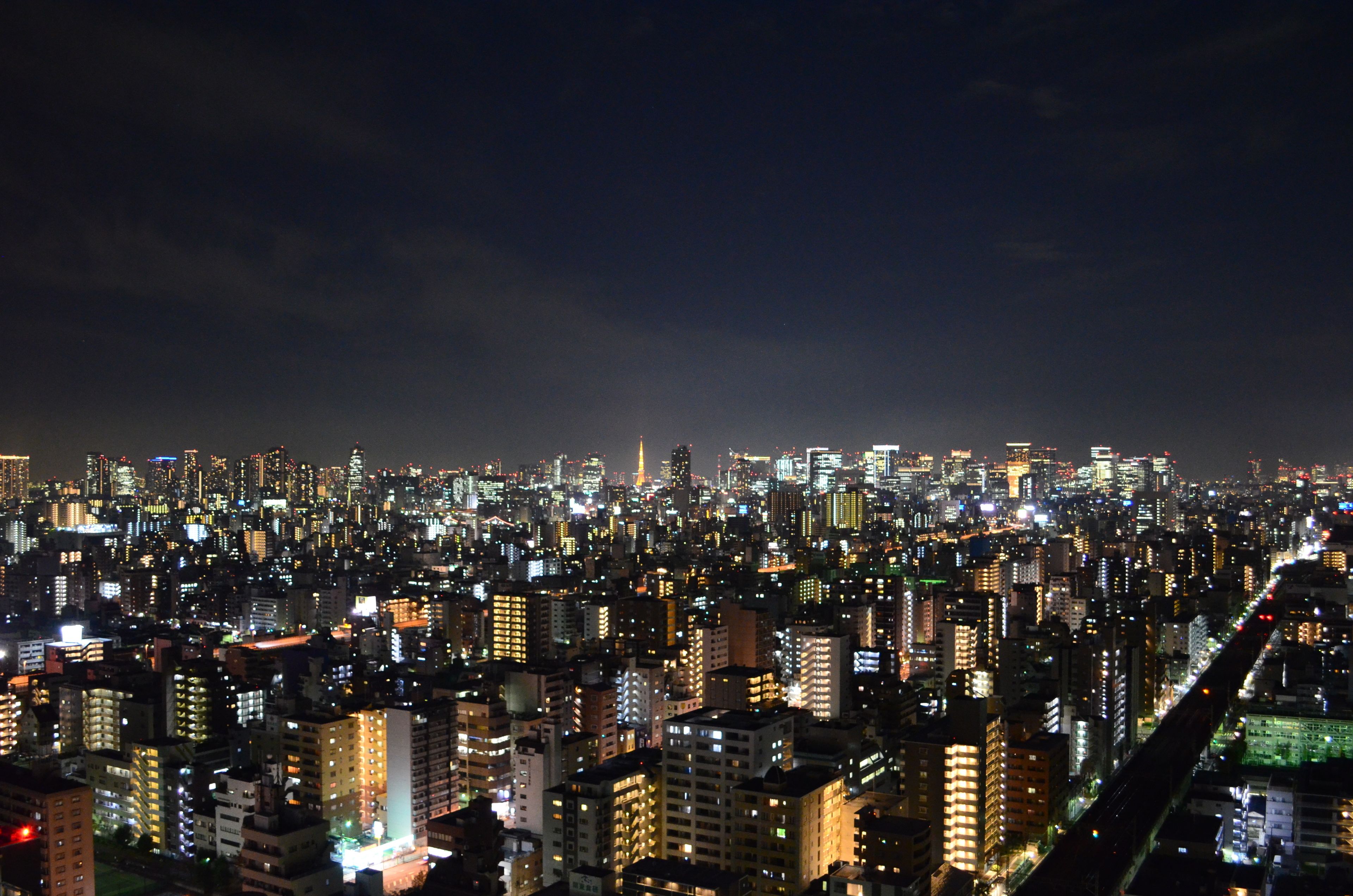 A nighttime cityscape with densely packed buildings and bright lights.