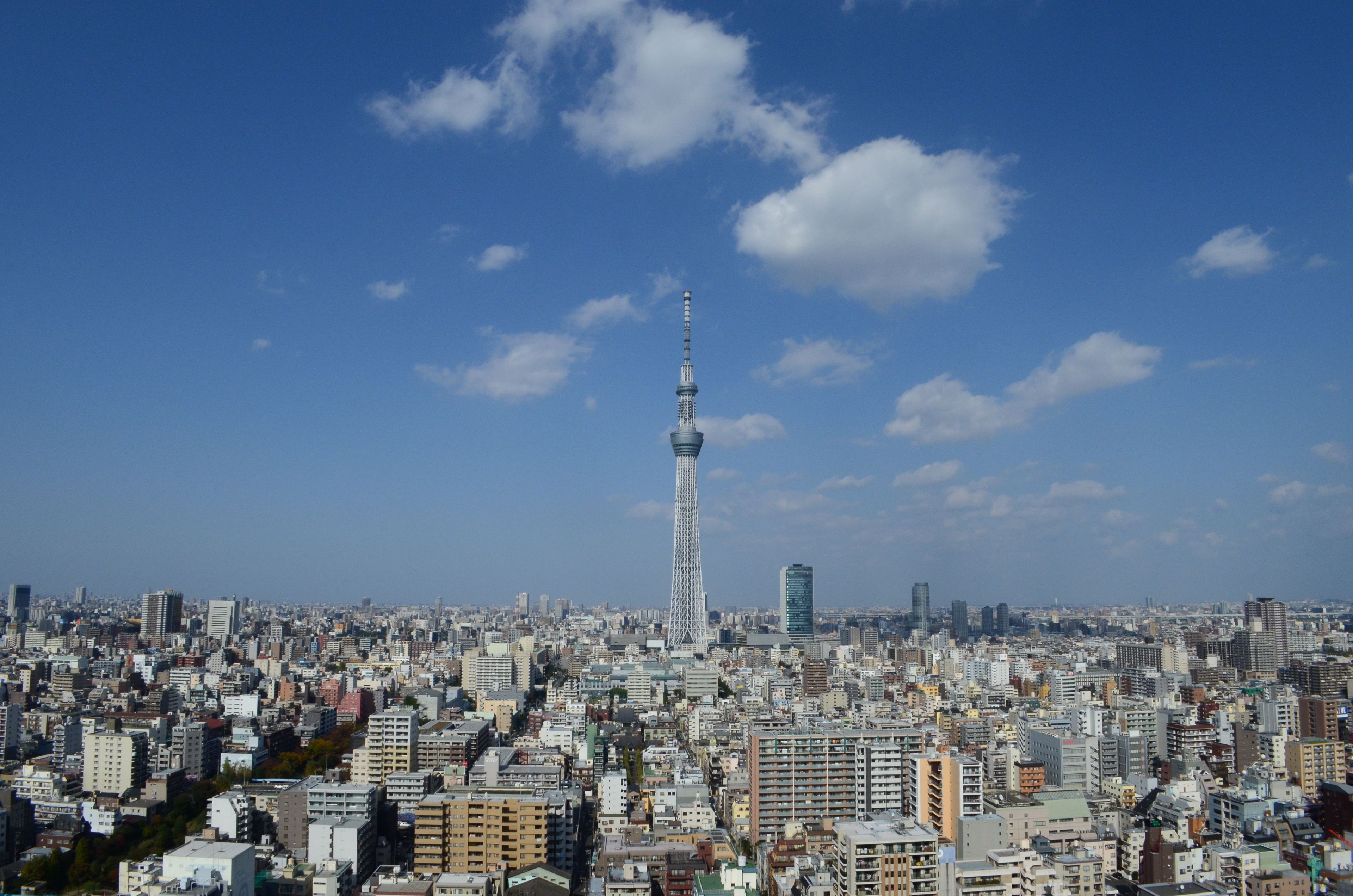 A cityscape with a prominent tower in the center, surrounded by dense urban buildings.