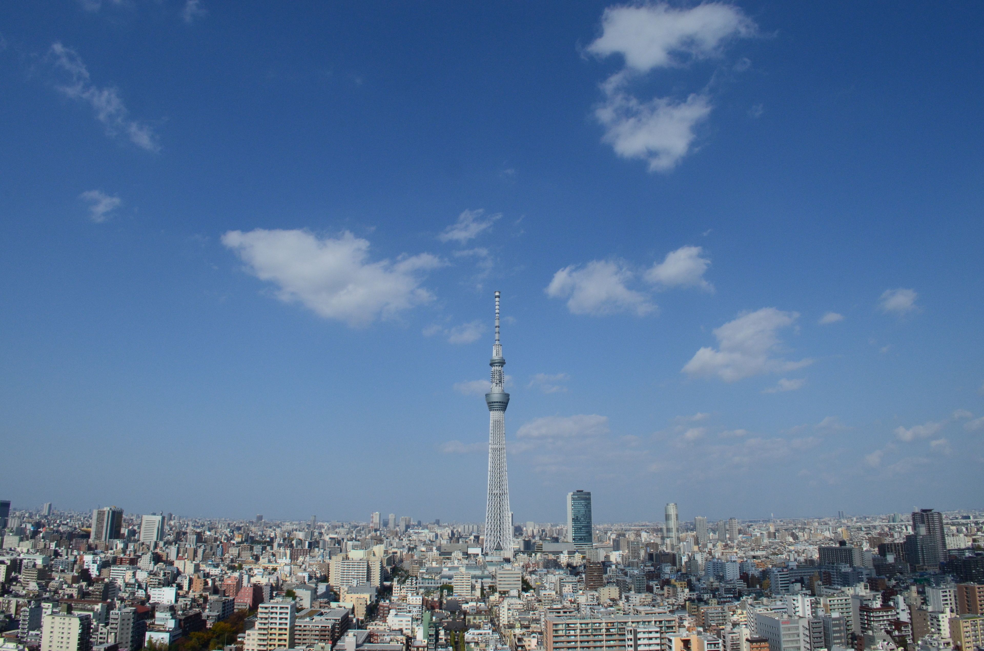A cityscape with a prominent tower in the center, surrounded by dense urban buildings.